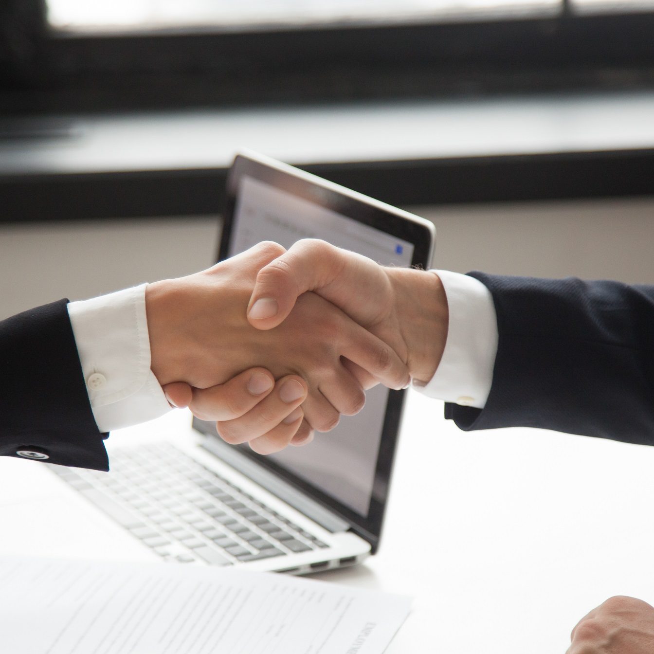 Businessman handshaking businesswoman as concept of good business deal and respect for new partner, successful partnership and great teamwork, hiring, close up view of male female hands shaking